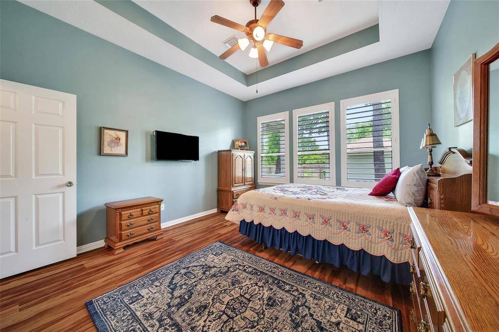 Large windows invite natural light into the bedroom.