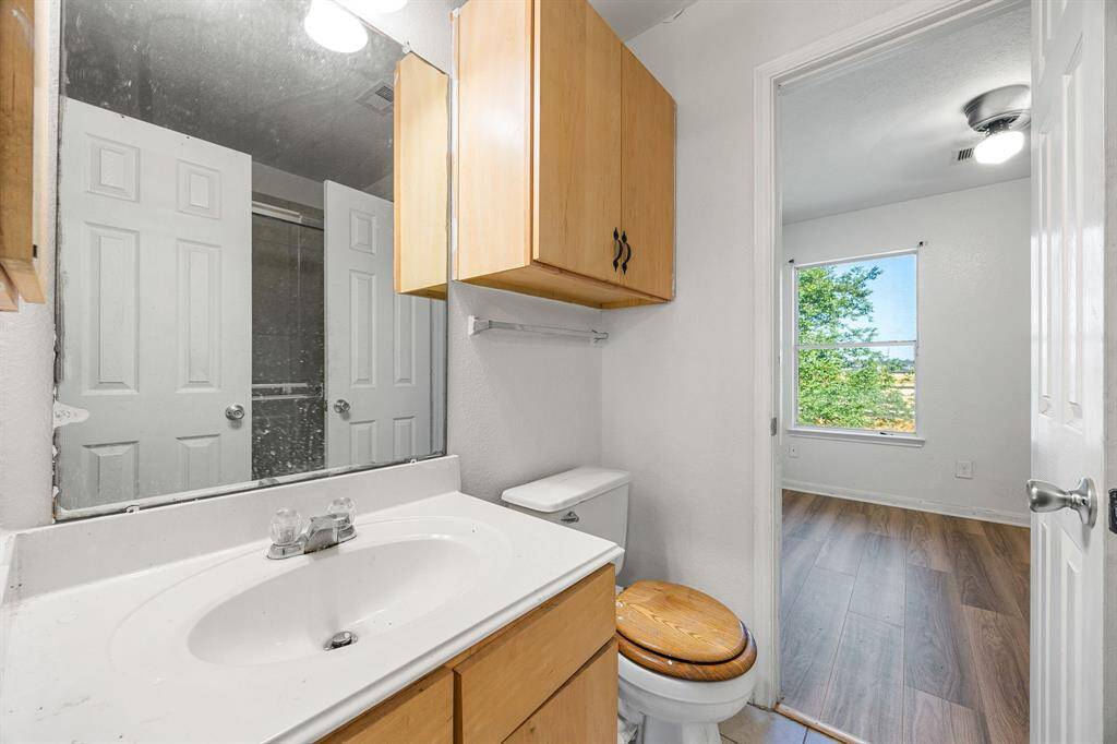 Fresh and functional, the primary bath features a bright and practical vanity area with a wide mirror, ample counter space, and cabinet storage ready for your daily routine.