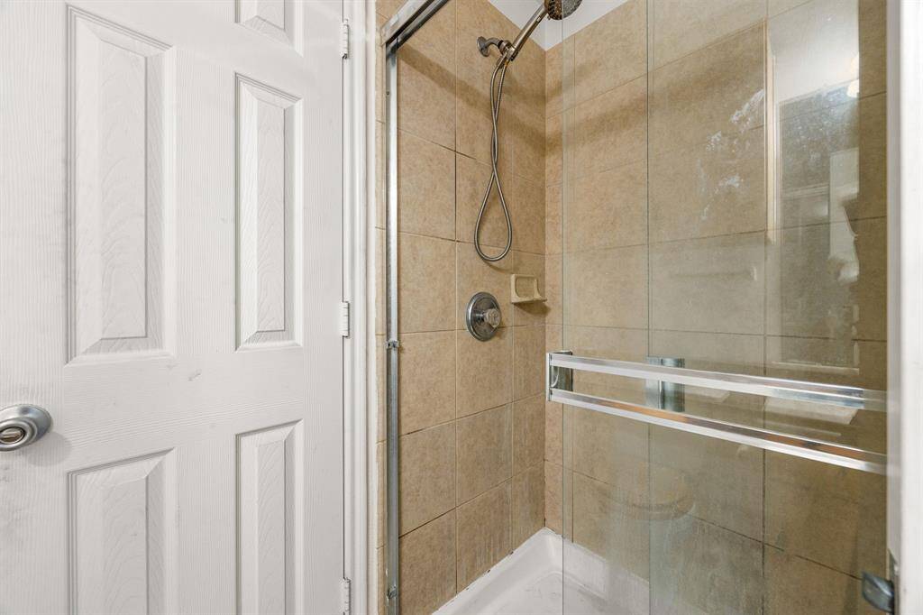 Bright, no-fuss walk-in shower featuring a glass sliding door and classic tile surround simple, practical, and ready for everyday use.