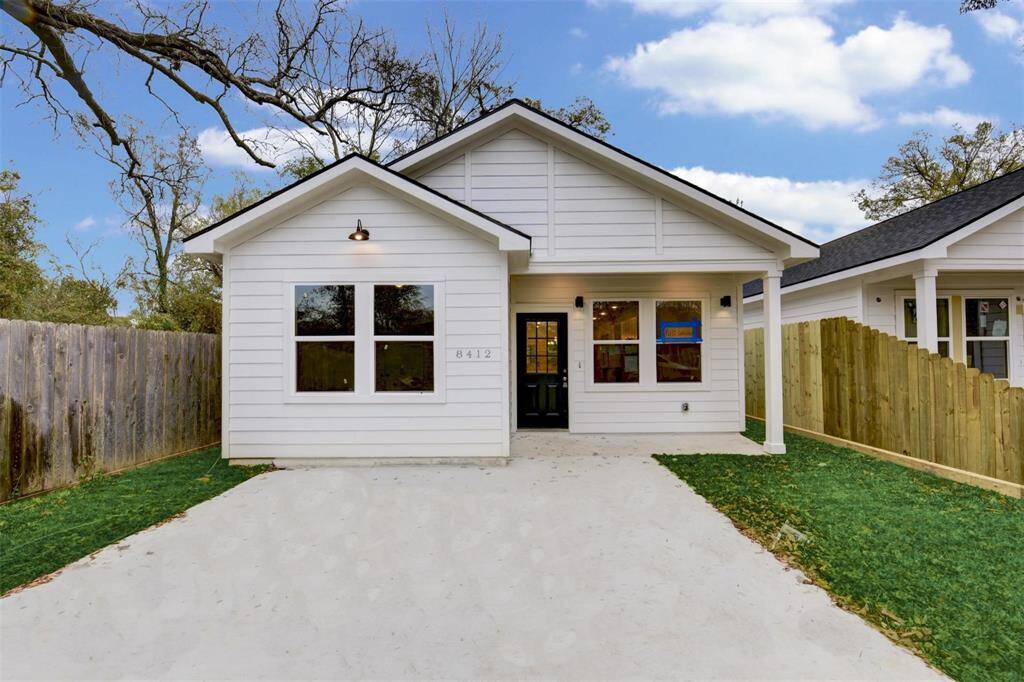 Beautiful single-story home with a sleek white exterior, inviting front porch, fenced yard, and generous driveway—ideal for comfortable living.
