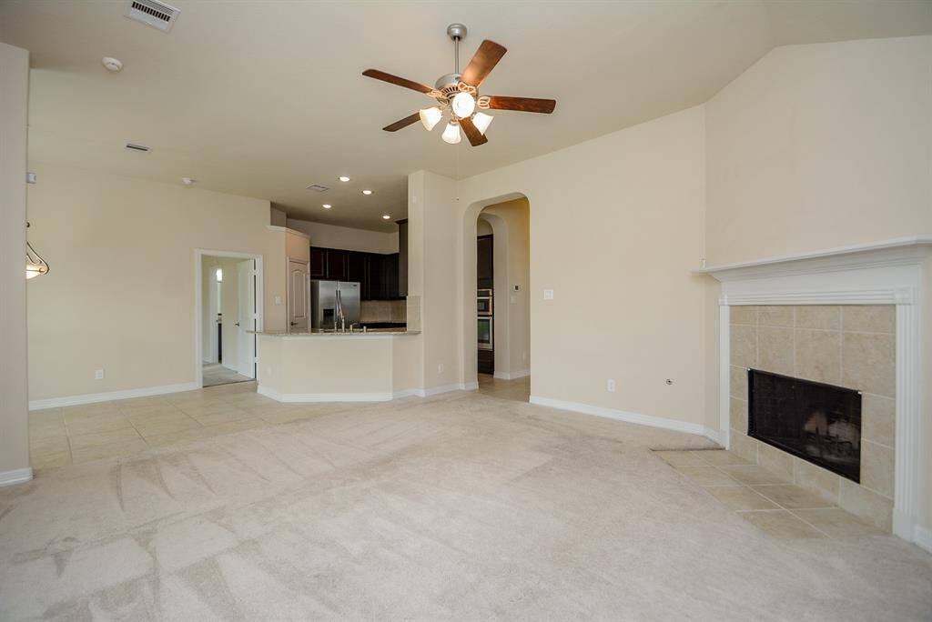 This is just a first taste of your enormous living/family area, which will surely become the heart of your home and activities! The gorgeous, high ceiling looks down upon the focal, wood burning fireplace and all the wall and carpeted floor space available. Hallways are tiled. Picture yourself in your favorite overstuffed chair, for a great view into the chef's kitchen ahead.