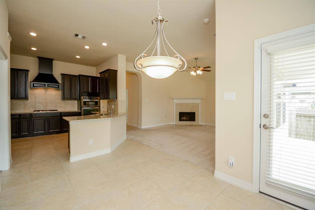 Here, in the breakfast nook, we have a handy door to the back yard patio/deck. This view also lets us appreciate the stunning chef's kitchen, only footsteps away from other spaces.