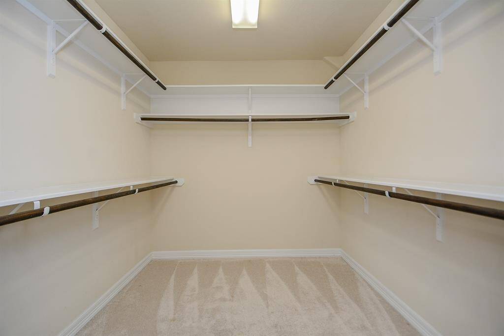 Goodness! This is your primary, ensuite, walk-in closet! Carpeted for comfort, built in shelves and plenty of railings will accomodate all your things! You may want to add a small boudoir chair or stool! Live it up!