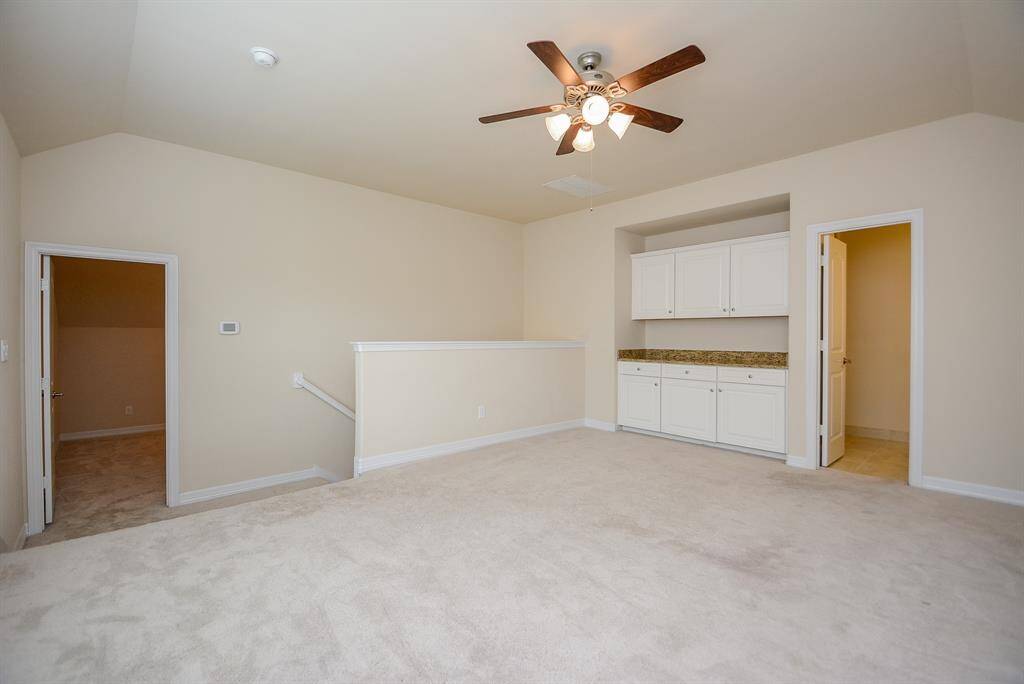 Here's a great, open view of the vast amount of floor and wall space on the 2nd story. Note the convenient cabinetry here! Game room and dry bar is great for entertaining . 3rd bathroom off the game room.