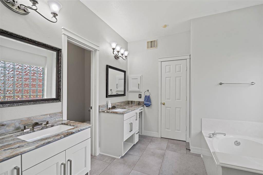 The primary en suite has been thoughtfully updated with upgraded vanities and lighting.