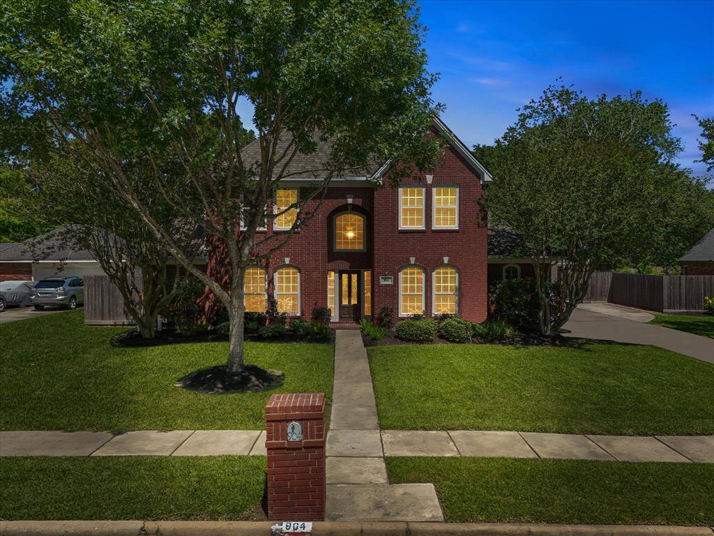 Welcome to 904 Middlecreek! Charming two-story brick home with a well-maintained front yard, mature trees, and a welcoming walkway.