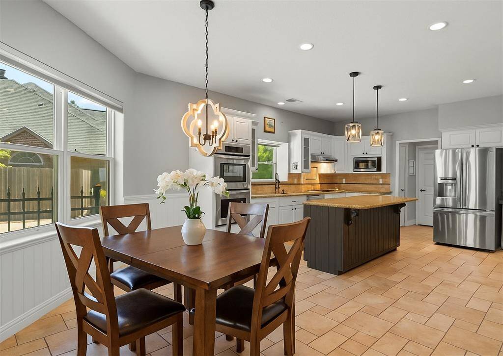 This inviting kitchen features modern stainless steel appliances, a spacious island, and elegant pendant lighting.