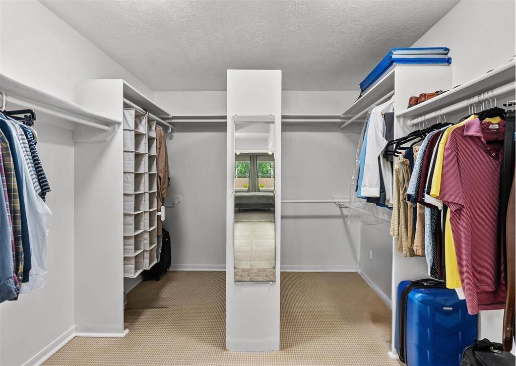 This spacious walk-in closet features ample hanging space and shelving.