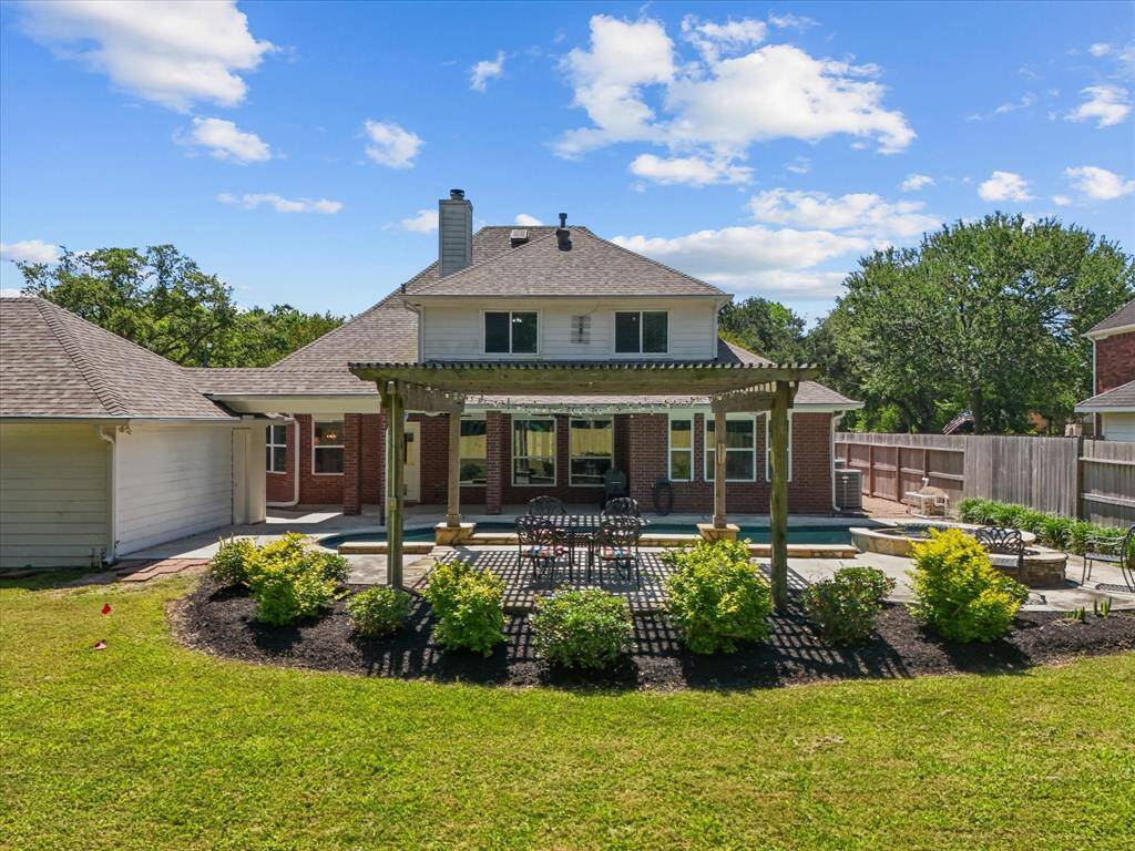 This photo showcases a spacious backyard, pergola and pool.