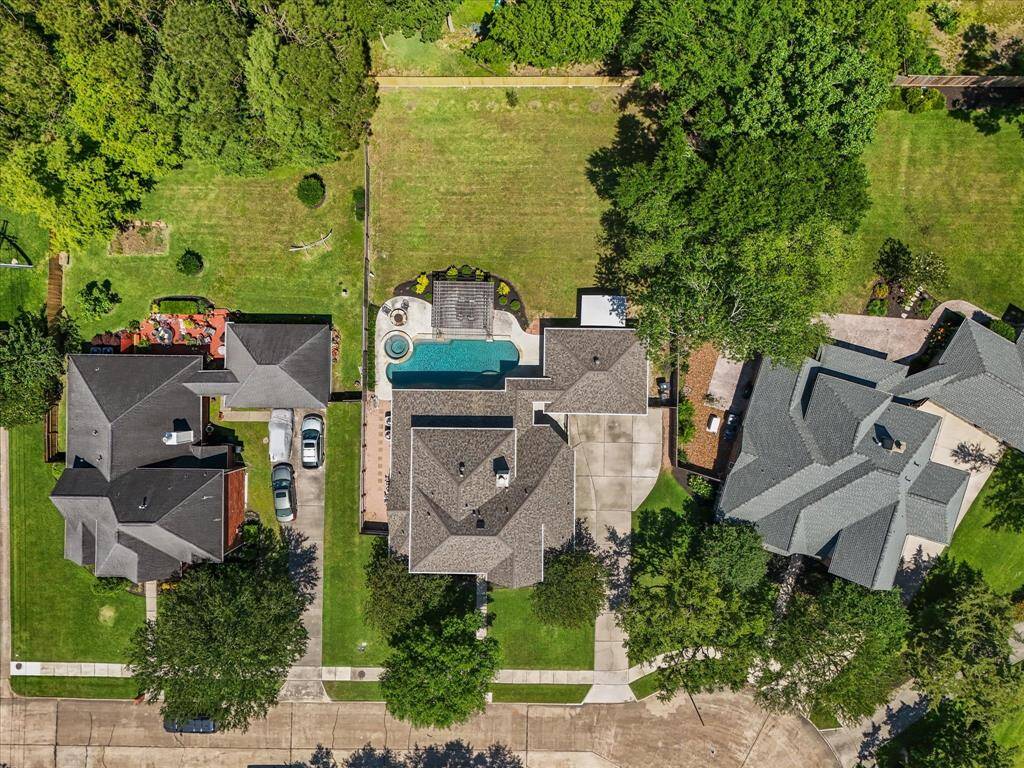 Aerial view showcasing lot layout, detached garage, and private driveway access.