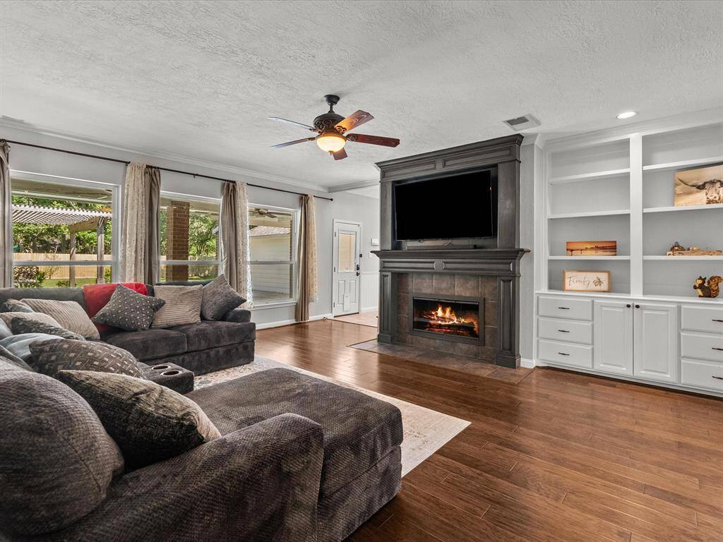 This inviting living room features a cozy fireplace and  built-in shelves for added storage.