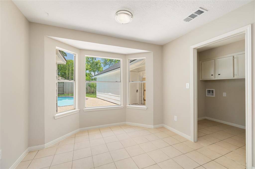 Enjoy your morning coffee in this cozy breakfast nook, featuring charming bay windows that offer serene views of the pool. The natural light pours in, creating a peaceful space to start your day while overlooking your outdoor oasis.