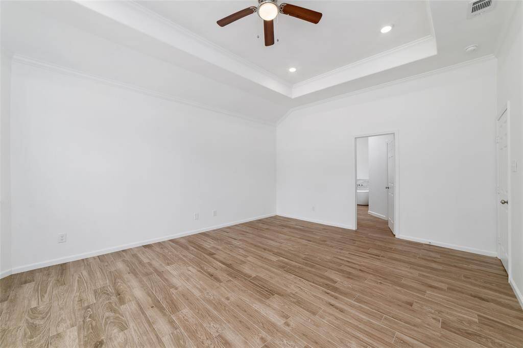 Primary suite with door to luxurious bathroom.