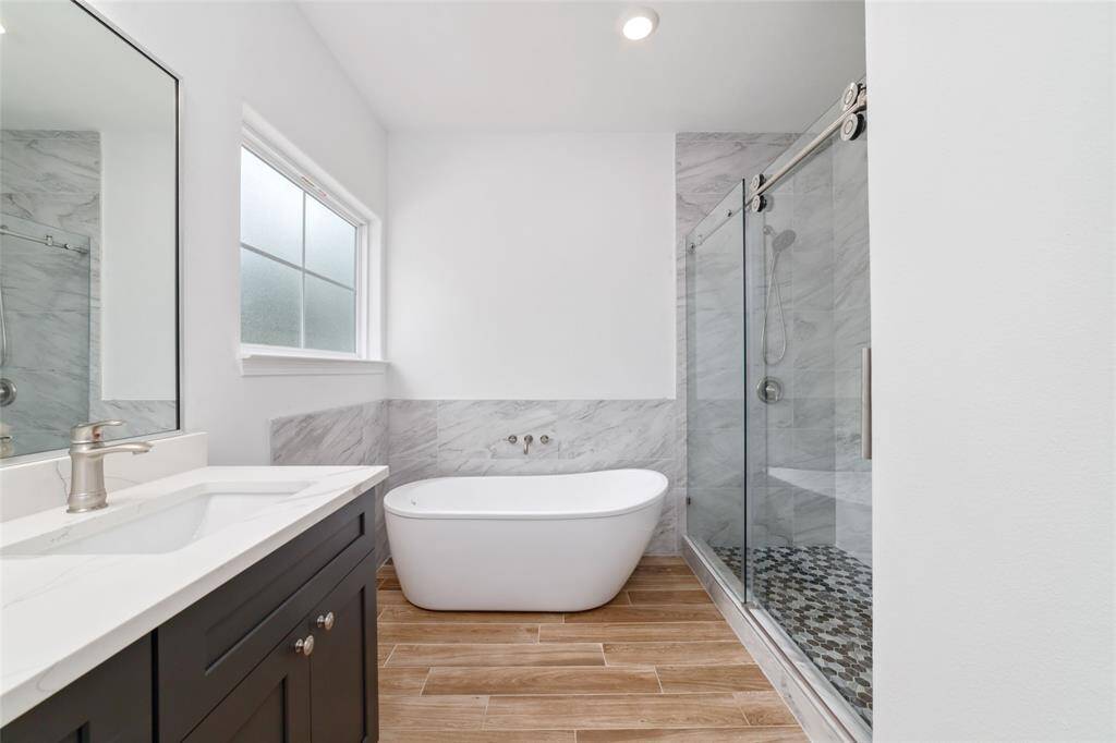 Primary bath features double sinks, soaking tub, oversized custom shower with bench, walk-in closet, and water closet.