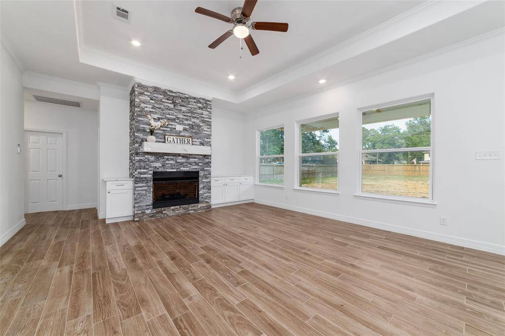 Living room features tray ceiling with a gorgeous gas fireplace with built-ins, and oversized windows, so you can enjoy lots of natural light.