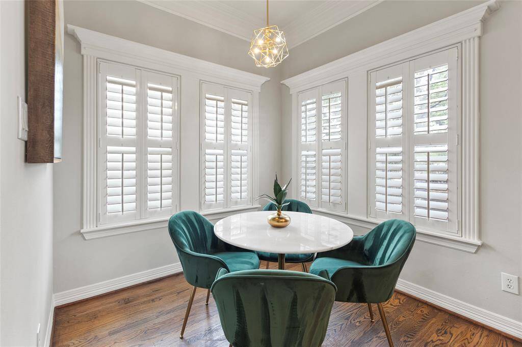 This cozy dining nook features largewindows with white shutters thatprovide ample natural light, highlightingthe hardwood floors and modern lightfixture above. Perfect for intimate mealsor morning coffee.