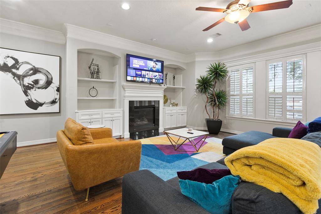 This spacious living area featureshardwood floors and includes a built-inbar, entertainment center and fireplace.Large windows with plantation shuttersprovide ample natural light, and there'sa ceiling fan for comfort.
