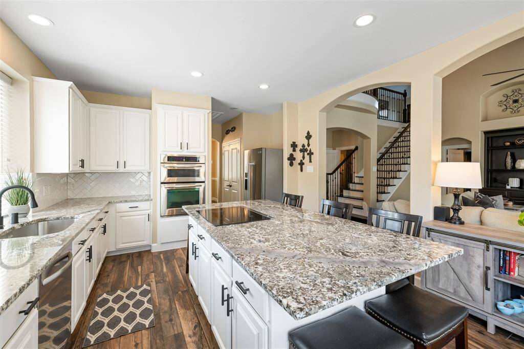 Another view of the kitchen with the double door pantry to the left of the refrigerator. Laundry room with electric and gas connections is across from the pantry.