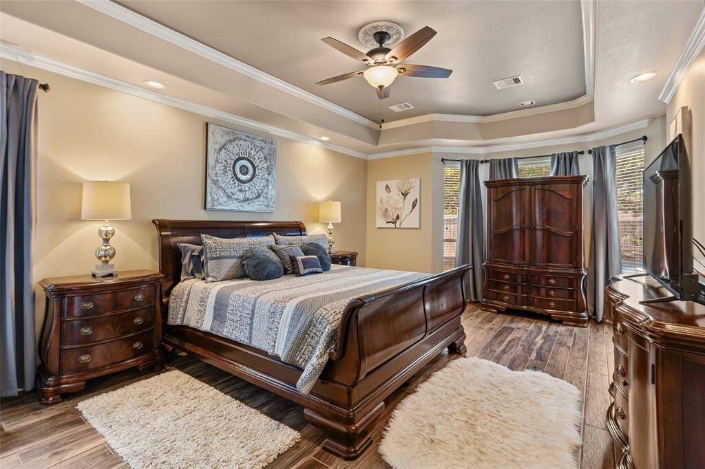 Spacious primary bedroom is on the first floor and boasts crown molding with a tray ceiling.