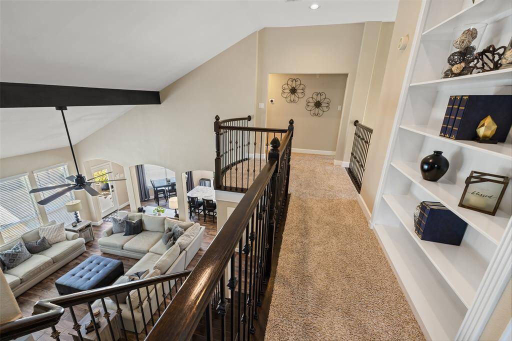 View from the top of the stairs overlooking the living room and kitchen.
