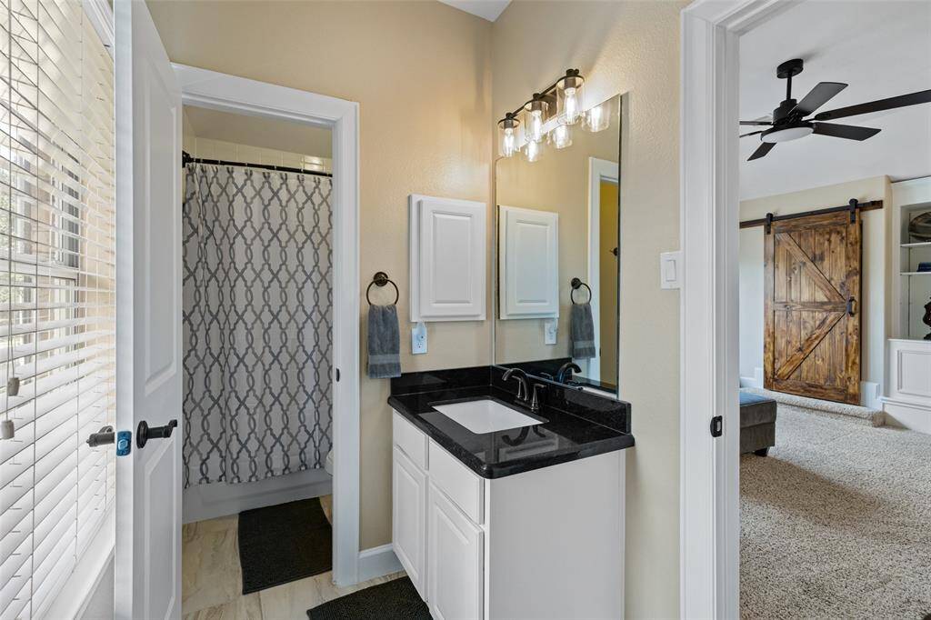 Secondary bath off of the game room has updated countertops, fixtures and flooring.