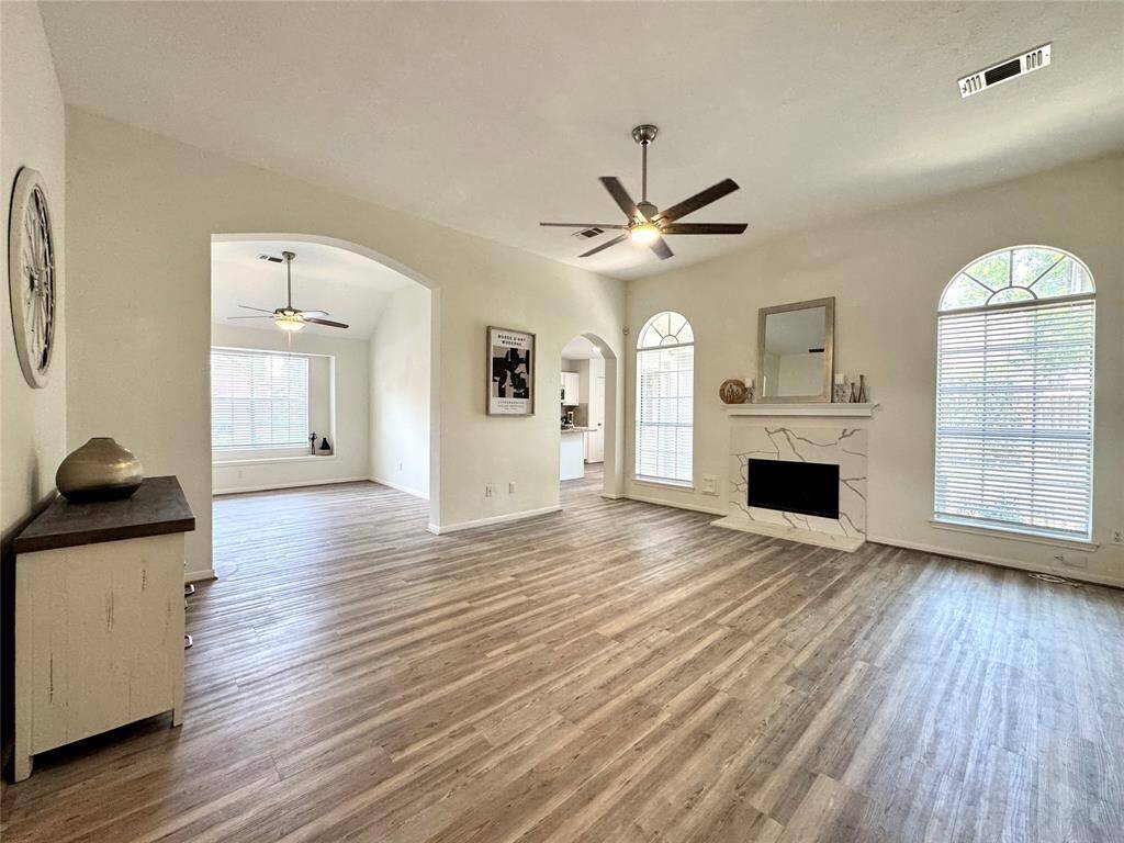 Spacious Family Room with gas-log fireplace, LVP flooring, and fan