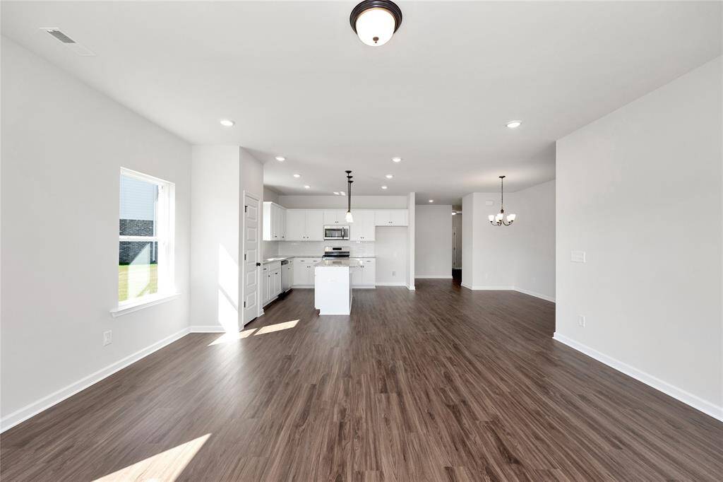The Pearson- Family Room into Kitchen. Home under construction. Sample floor plan photo used for illustrative purposes only. Upgrades, selections options, and colors will vary.