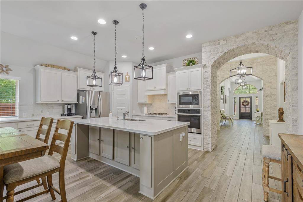 The arched stone accent walls are stunning along with the wood look tile.