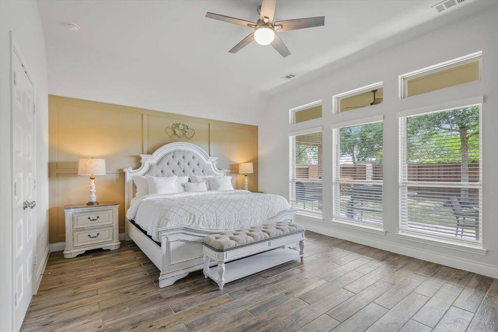 Discover elegance in this primary suite featuring a stunning accent wall and soaring windows for abundant natural light.