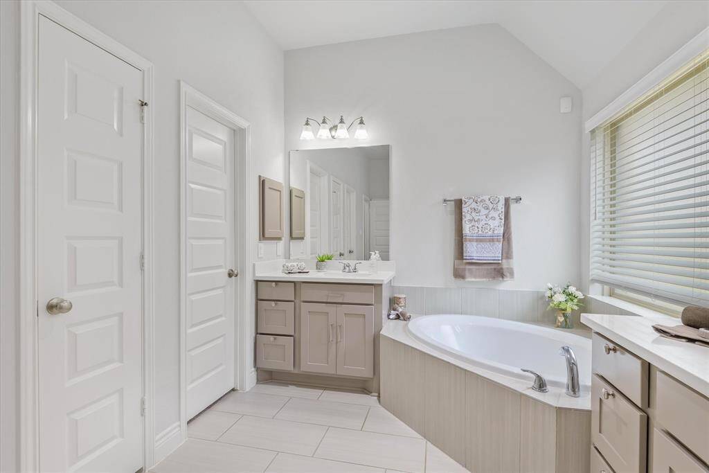 Discover tranquility with neutral cabinetry and elegant tiles, complemented by a luxurious soaking tub for the ultimate escape.