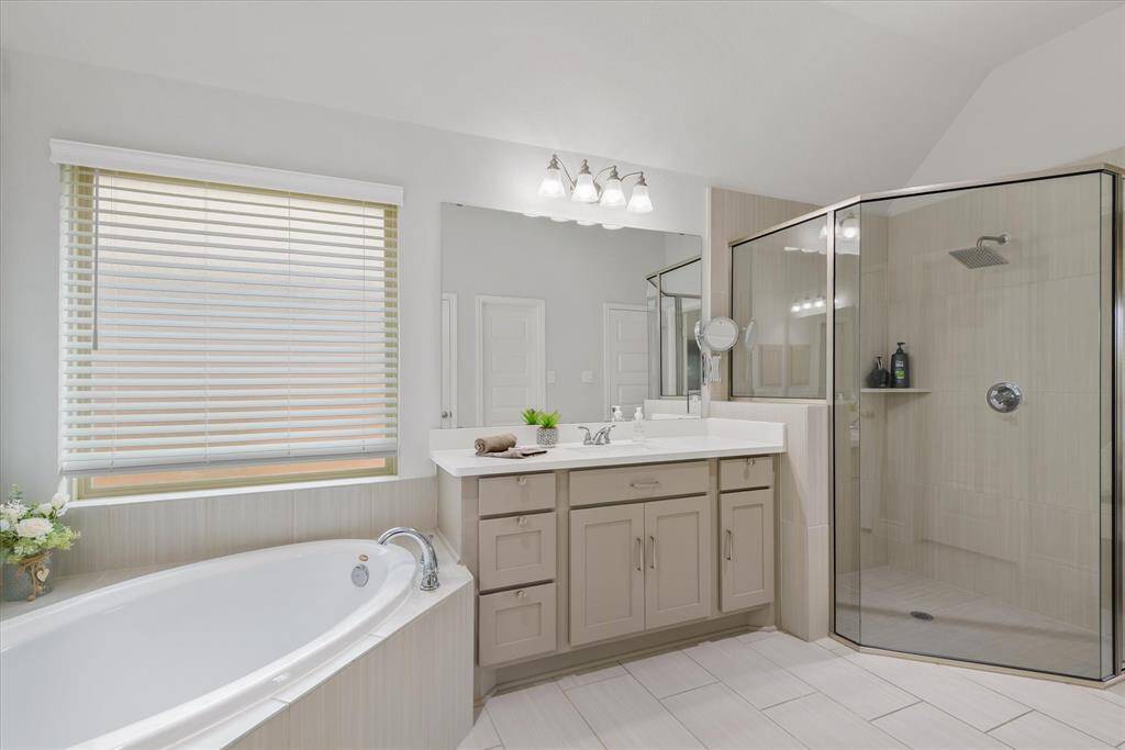 Experience luxury and comfort in this elegant bathroom, featuring a spacious soaking tub, modern glass shower, and sleek double vanity. Your serene retreat awaits.