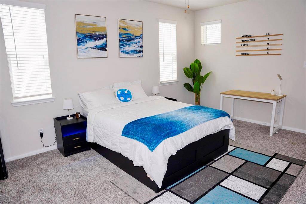 Primary bedroom with a bed, LED night stands, desk, TV stand, TV and a MINI FRIDGE!