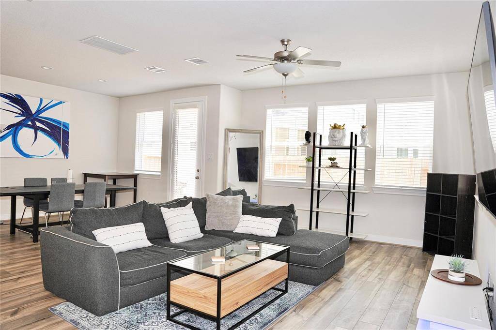 Fully equipped living room with an L-shaped couch, coffee table, tv stand and TV included