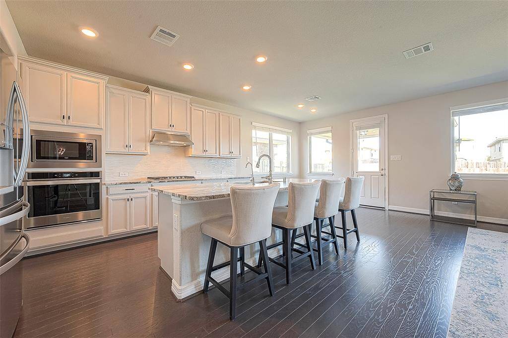 Behold at the exquisite granite kitchen island, a focal point that combines beauty with functionality. The granite kitchen bar is a standout feature, offering both style and practicality in this inviting space.