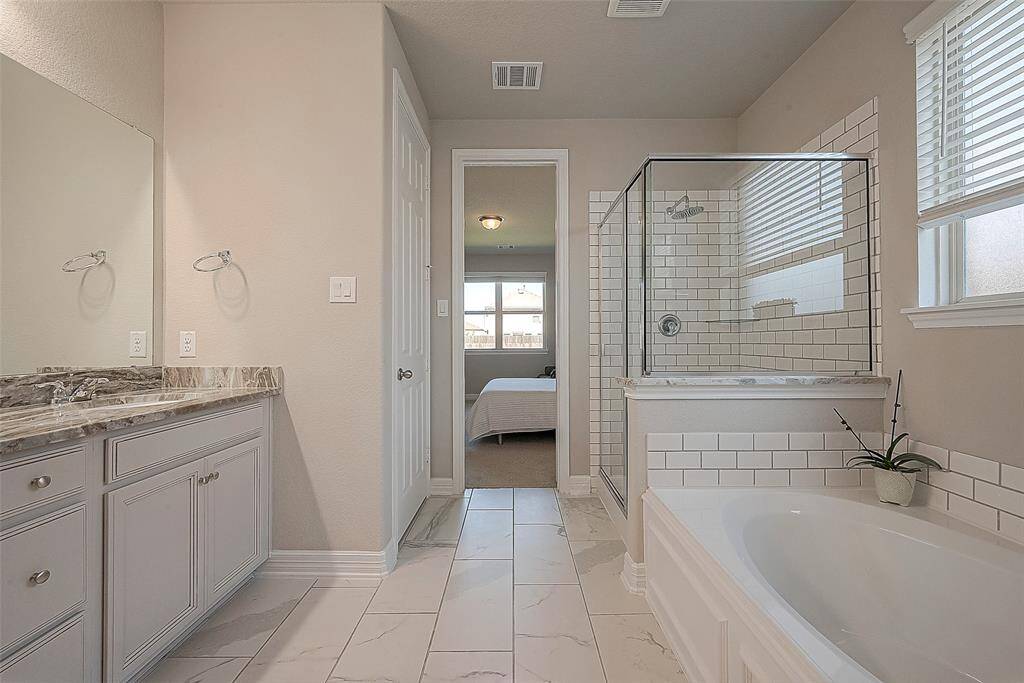 The double sink offers enough space for getting ready with no rush. This bathroom provides the perfect backdrop for relaxation and rejuvenation.