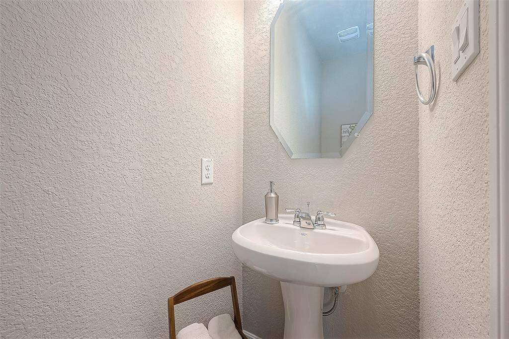 The powder room is thoughtfully designed to make the most of its footage. A compact vanity sink provides essential functionality without overwhelming the space.