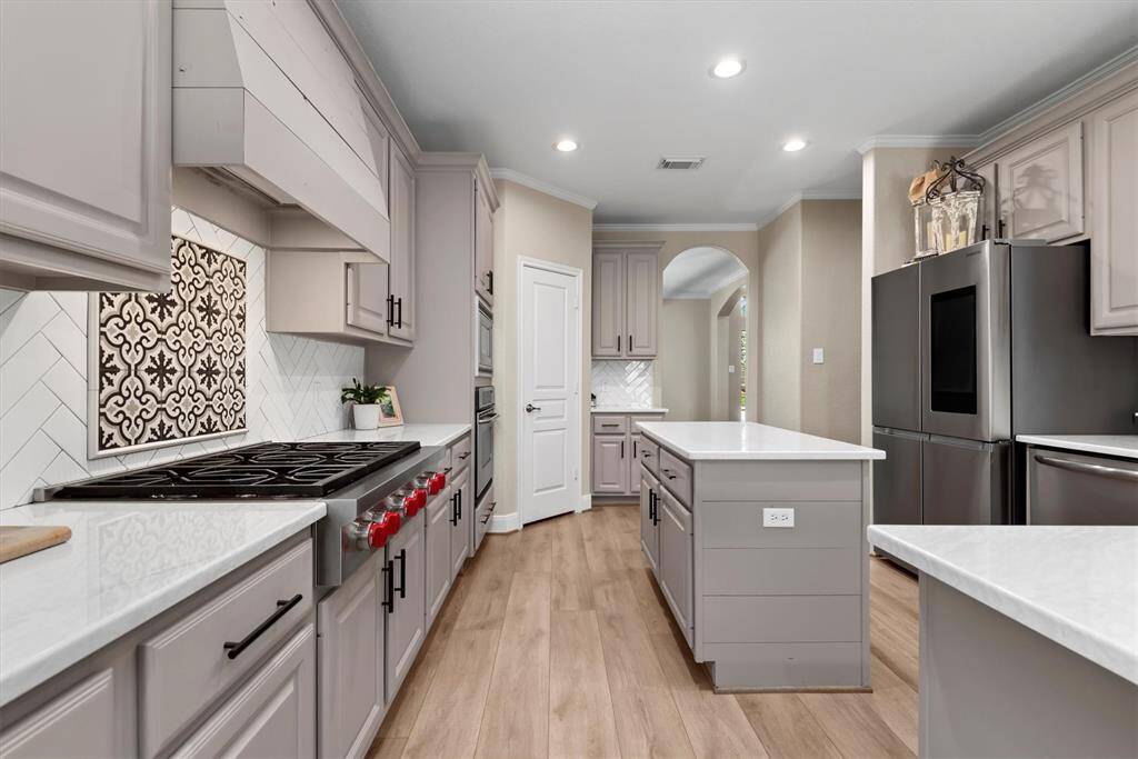 The stylish tile backsplash and 6-burner gas cooktop are truly a chefs kiss!