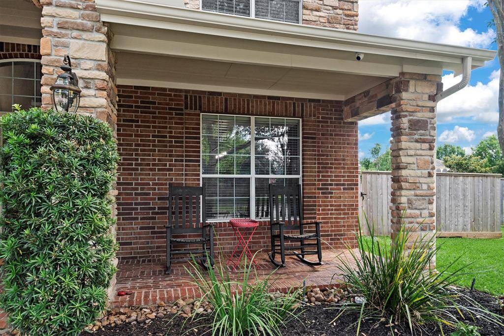 Charming front porch with brick and stone accents, perfect spot for relaxation.