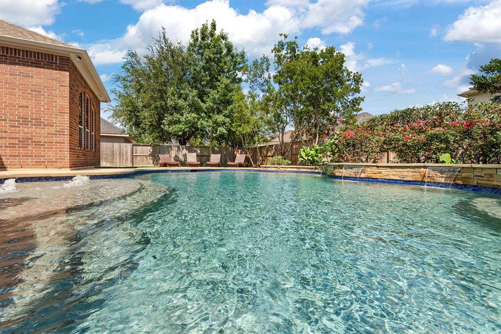 The pool is surrounded by lush landscaping, creating a serene and inviting outdoor space.