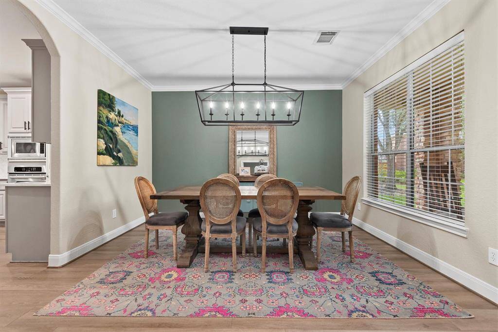 The formal dining room features a stylish light fixture and a big window that lets in plenty of natural light. It’s right next to the kitchen, making it a cozy and welcoming spot for meals and get-togethers.