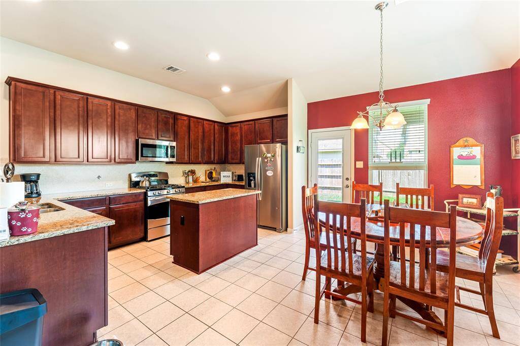 Bright and spacious kitchen with ample counter space, a large island, and plenty of room for a dining table, whether large or small, plus a brand-new microwave and 2021 Whirlpool fridge that stay with the home.
