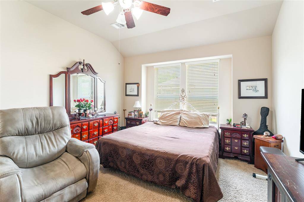 Bright and sizable primary bedroom, easily fitting a king-sized bed with plenty of additional room, leading into an en-suite bath featuring a glass-enclosed shower, garden tub, double vanity, walk-in closet, and private toilet room.