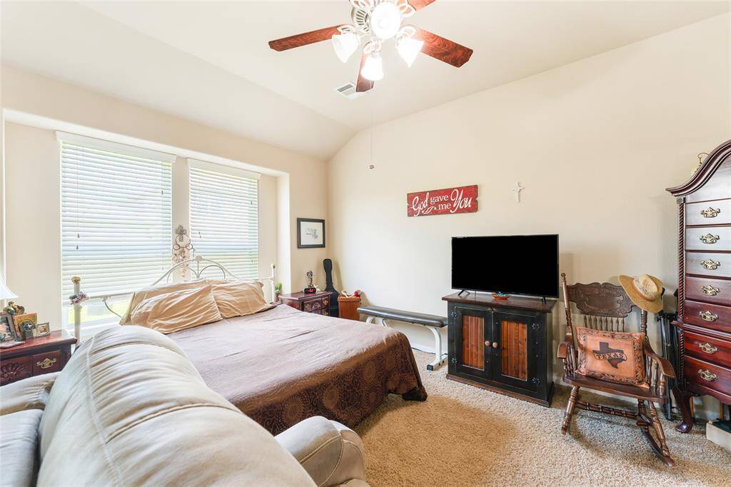 Bright and sizable primary bedroom, easily fitting a king-sized bed with plenty of additional room, leading into an en-suite bath featuring a glass-enclosed shower, garden tub, double vanity, walk-in closet, and private toilet room.