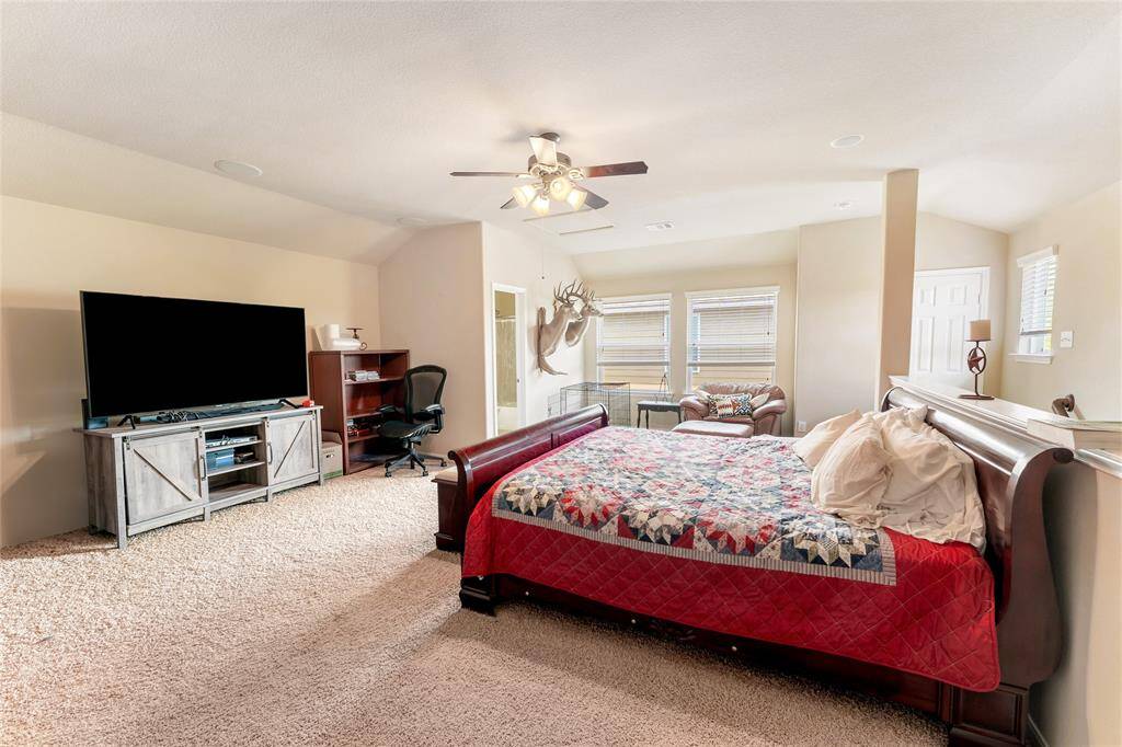 Spacious upstairs game room or flex space, featuring a full bath, closet, and plenty of natural light from multiple windows, with recessed lighting and a ceiling fan for added comfort.