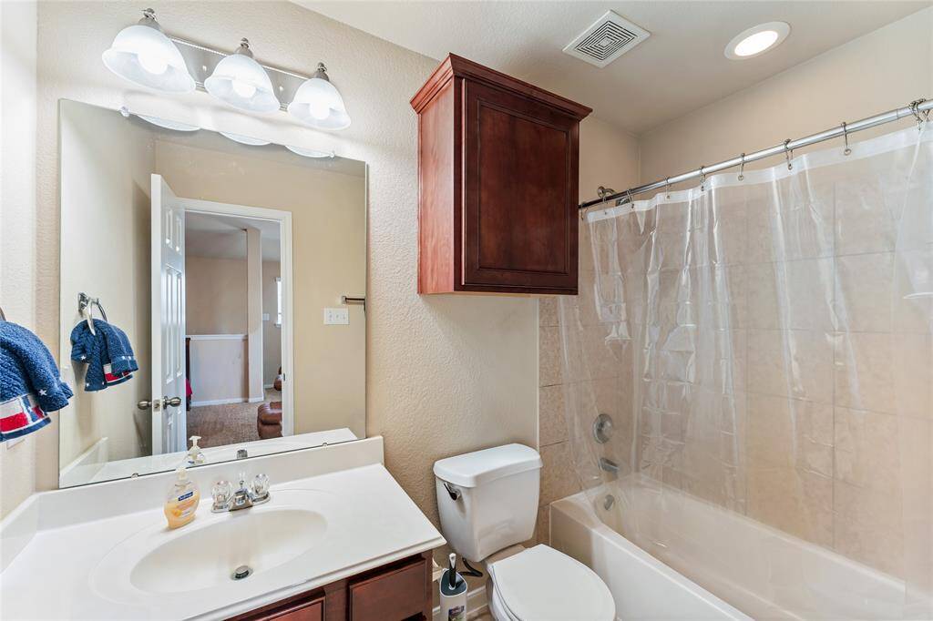 Spacious upstairs game room or flex space, featuring a full bath, closet, and plenty of natural light from multiple windows, with recessed lighting and a ceiling fan for added comfort.