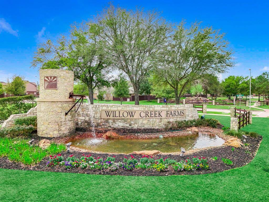 Entrance to Willow Creek Farms, featuring a serene pond fountain, located in Katy ISD within Waller County.