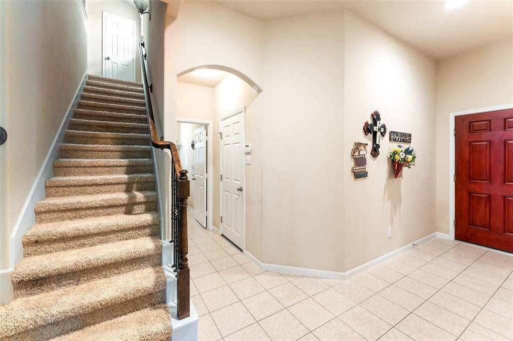 Welcoming, open entryway with access to the laundry room, garage, and upstairs flex space with full bath and closet.