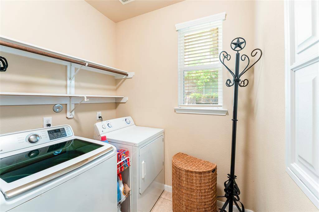 Spacious laundry room filled with natural light, complete with a Samsung washer and GE dryer included with the home.