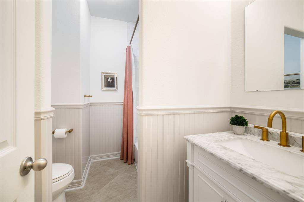 The secondary bathroom has been wonderfully updated with new vanity, sink and faucet, a gorgeous zellige tile shower surround, plus beadboard paneling.
