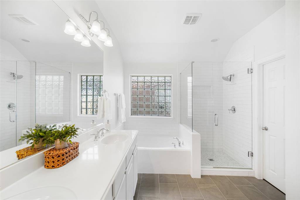 The spa-like bathroom has a garden tub and remodeled shower with the wall and floor tile also recently upgraded.